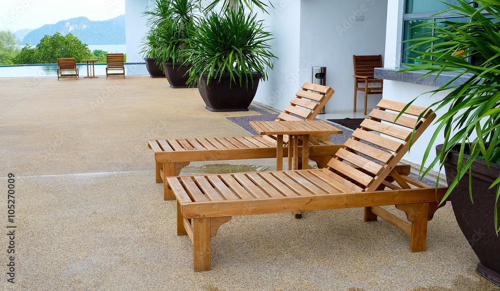 Fototapeta premium Wooden benchs beside the swimming pool in the resort