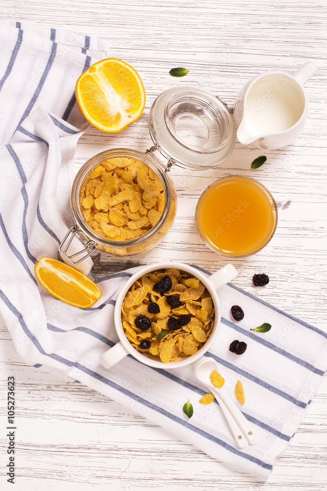 Breakfast concept with corn flakes, milk, dry cranberry and orange juice Breakfast concept with corn flakes, milk, dry cranberry and orange juice