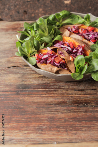 baked sweet potatoes in the oven with carrots and cabbage