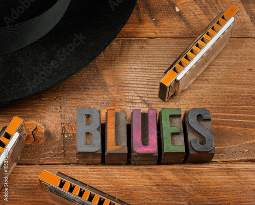 blues harps in wood background and word blues in letterpress type
