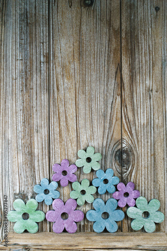 Colorful wooden flowers on wooden background, copy space