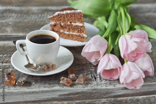 cup of coffee, cake, pink tulips on wooden background
