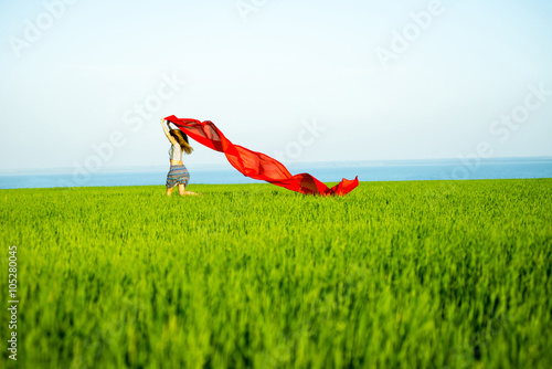 Young happy woman in wheat field with fabric. Summer lifestyle