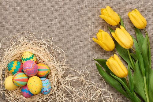 Easter background,eggs, yellow tulips on sackcloth
