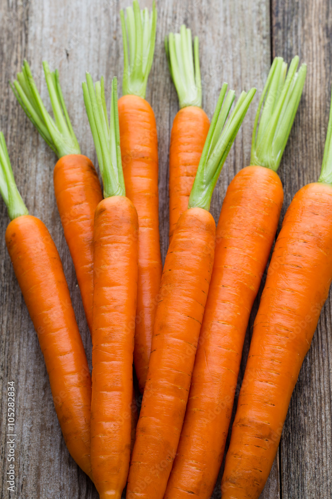 Fresh carrots bunch on rustic wooden background. Fresh carrots bunch on rustic wooden background.