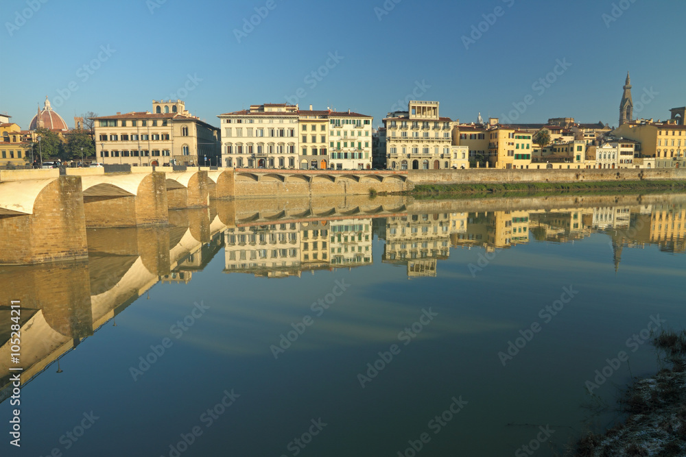 Monumental buildings beautifully reflected  in water of river Arno in Florence