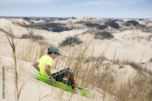  Boy sledding with sand dunes. Monahans Sandhills State Park, Te photo