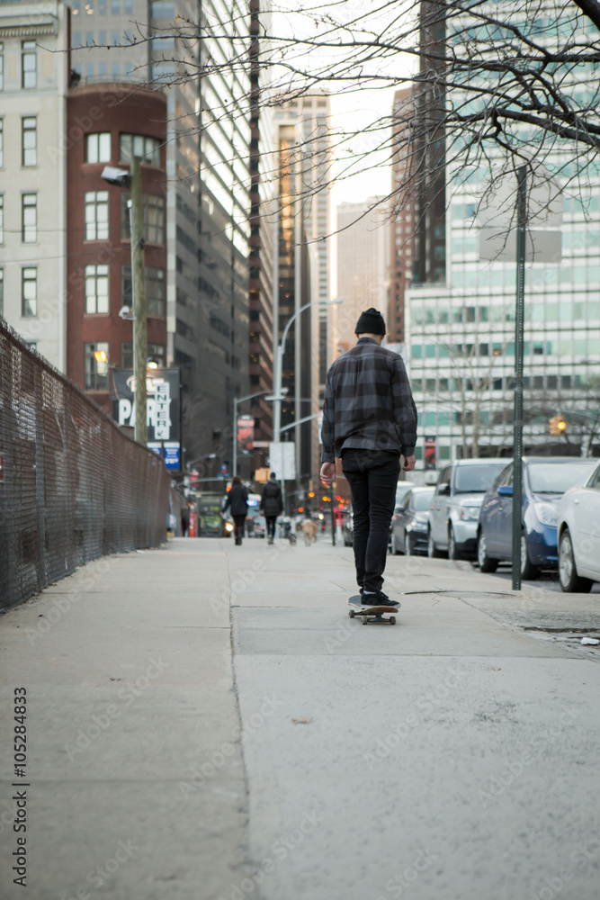 Young male skateboarder cruising down on the bridge overpass