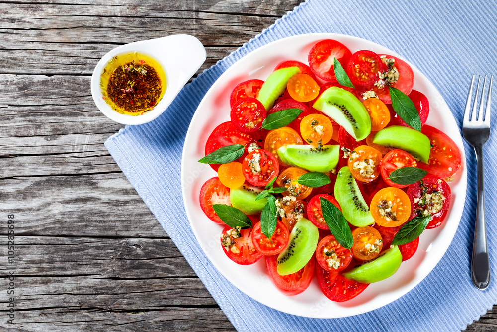 tomato salad with kiwifruit, dressing olive oil with aromatic he tomato salad with kiwifruit, dressing olive oil with aromatic he