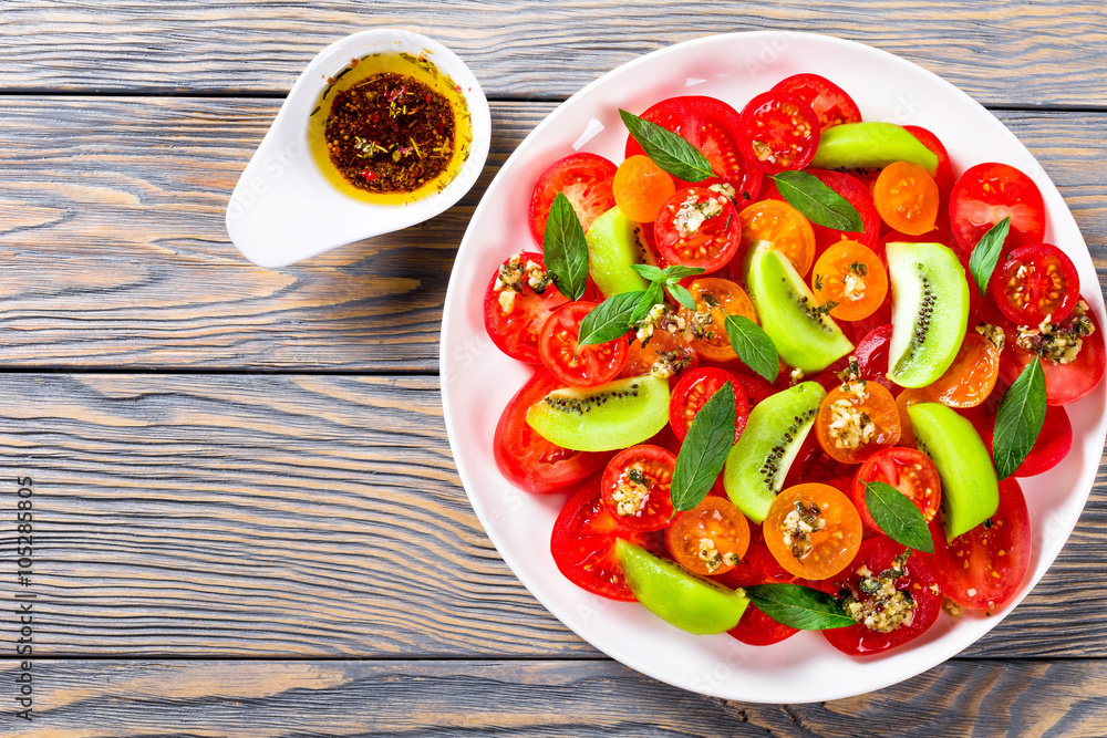 salad of yellow red and cherry tomatoes, kiwi fruit, mint salad of yellow red and cherry tomatoes, kiwi fruit, mint