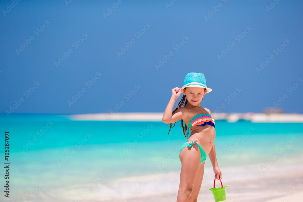 Adorable little girl in hat at beach during summer vacation