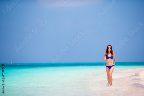 Young woman in swimsuit running and enjoying time at the beach © travnikovstudio
