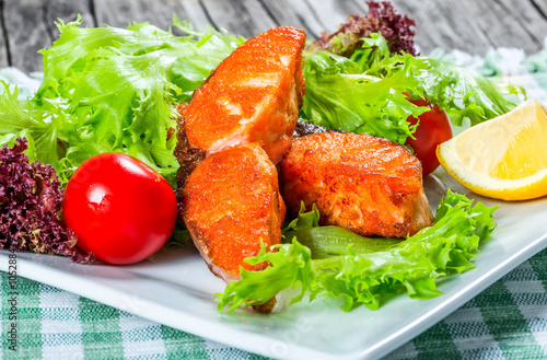 fried salmon with fresh salad, cherry tomato and lemon. photo