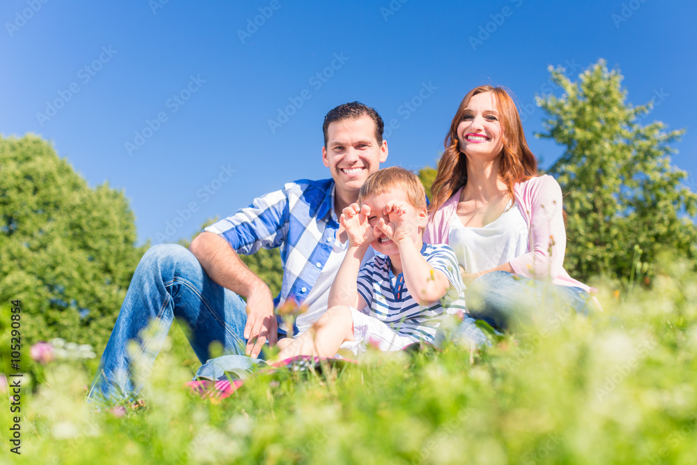 Fototapeta premium Family having fun sitting in the green grass