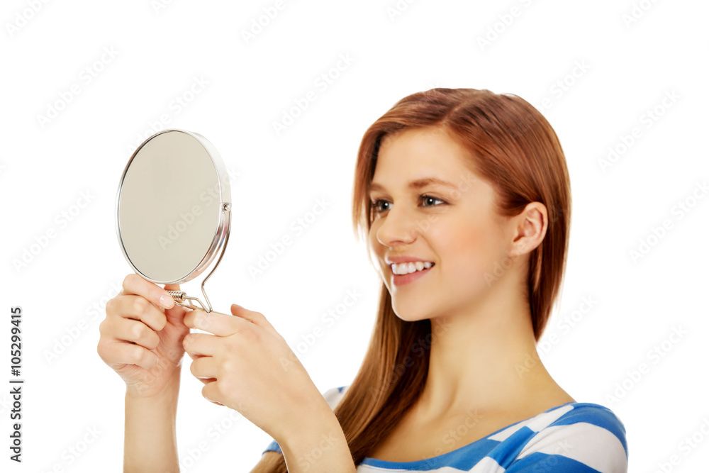Teenage beautiful woman looking in a mirror Teenage beautiful woman looking in a mirror