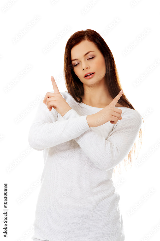 Confused young woman pointing in two different directions Confused young woman pointing in two different directions