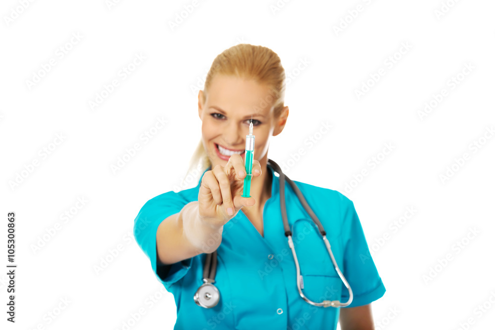 Smiling female doctor or nurse with stethoscope holding syringe Smiling female doctor or nurse with stethoscope holding syringe