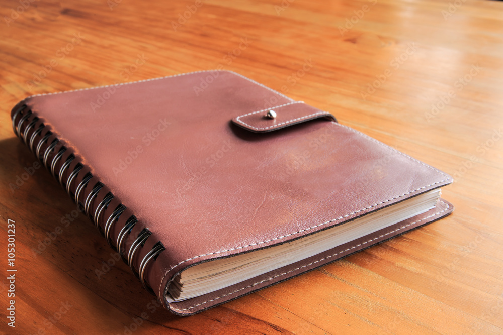 The old leather book for memo schedule diary on wood table background. The old leather book for memo schedule diary on wood table background.