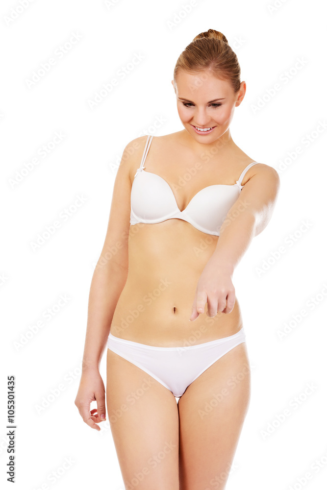 Young woman in white lingerie pointing for copyspace or something Young woman in white lingerie pointing for copyspace or something