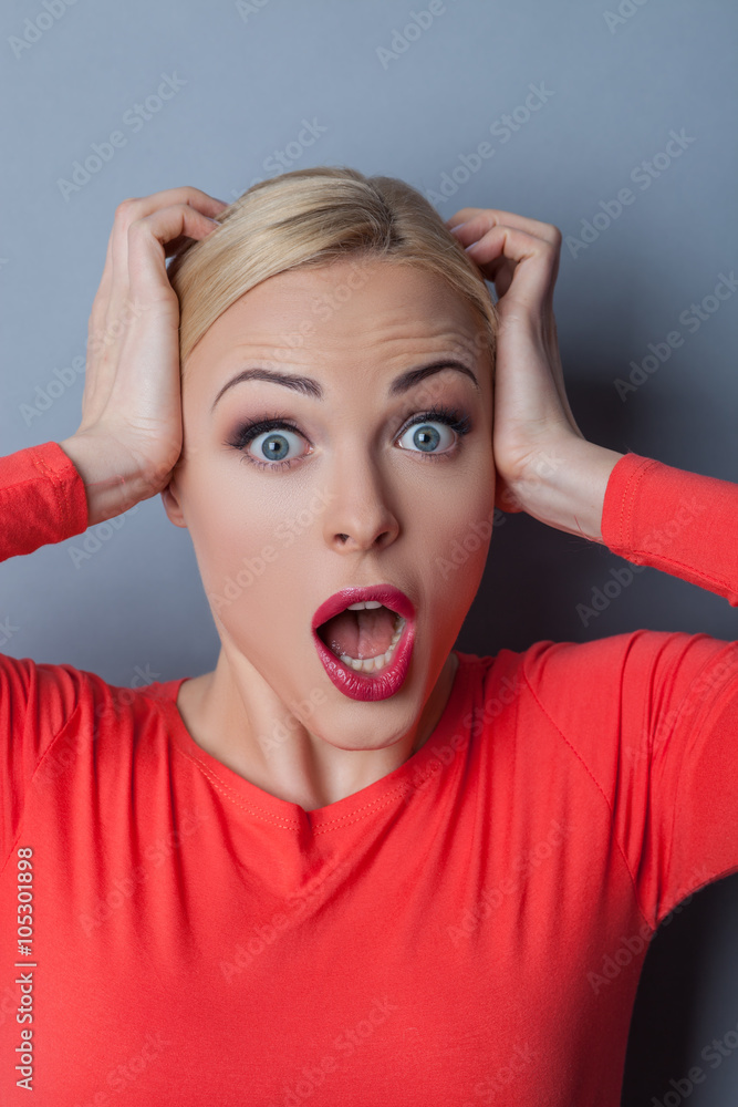 Cheerful blond woman is evincing her shock Cheerful blond woman is evincing her shock