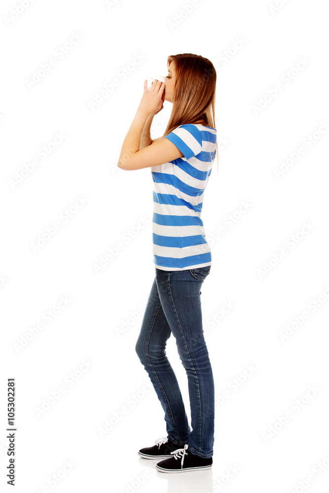 Teenage ill woman using a tissue