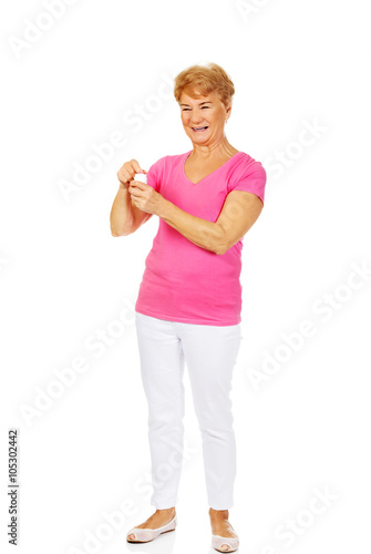 Smiling senior woman holding jar of pills © Piotr Marcinski