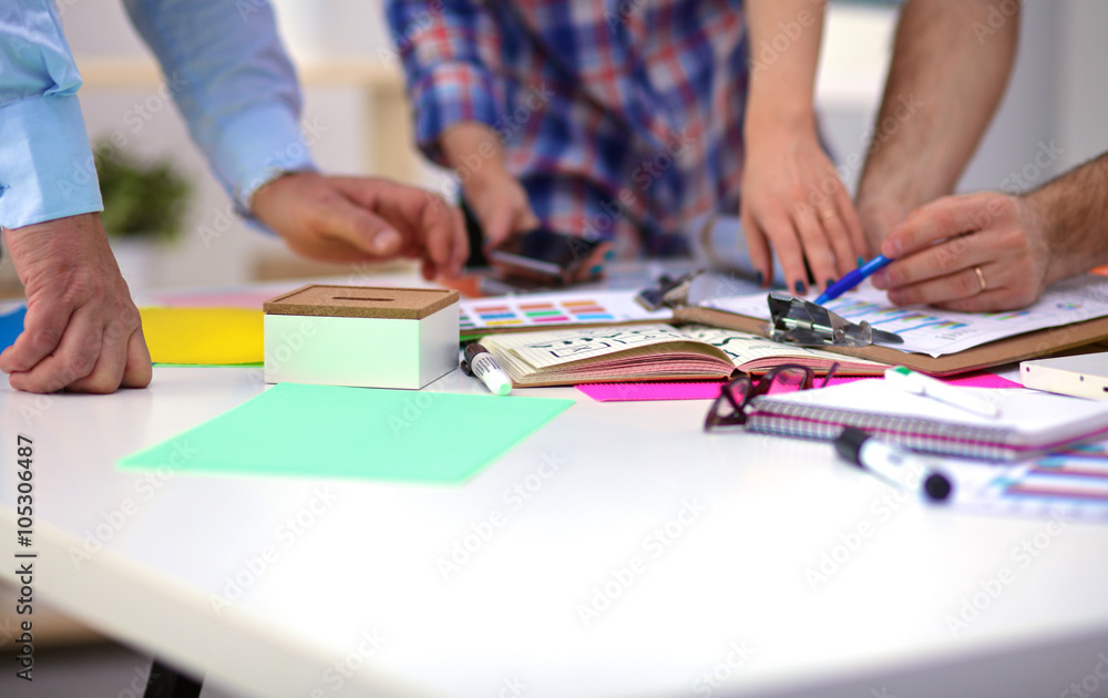 Close-up of three young creative designers working on project together. Team work