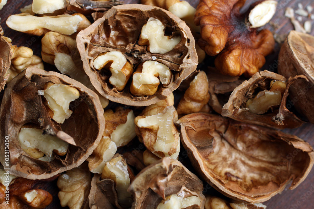 walnuts are broken on a brown wooden table walnuts are broken on a brown wooden table