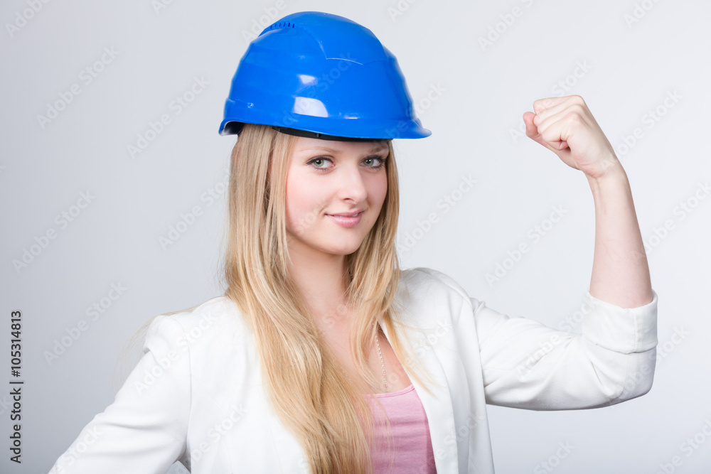 Junge Ingenieurin mit Helm zeigt sich kraftvoll Junge Ingenieurin mit Helm zeigt sich kraftvoll