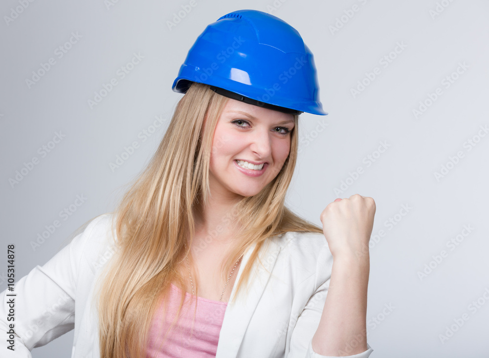 Junge Ingenieurin mit Helm zeigt ihre Siegesfaust Junge Ingenieurin mit Helm zeigt ihre Siegesfaust