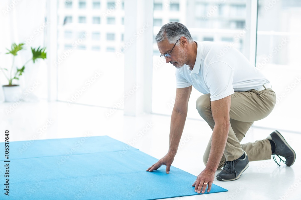 Physiotherapist laying exercise mat