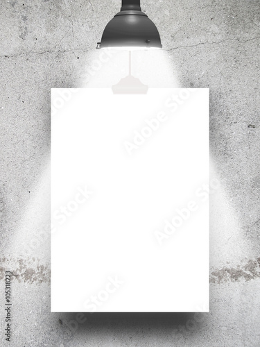 Close-up of one hanged paper sheets with lamp on grey weathered and cracked concrete wall background