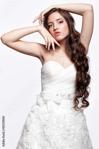 Portrait of beautiful young brunette woman bride in white Weddi