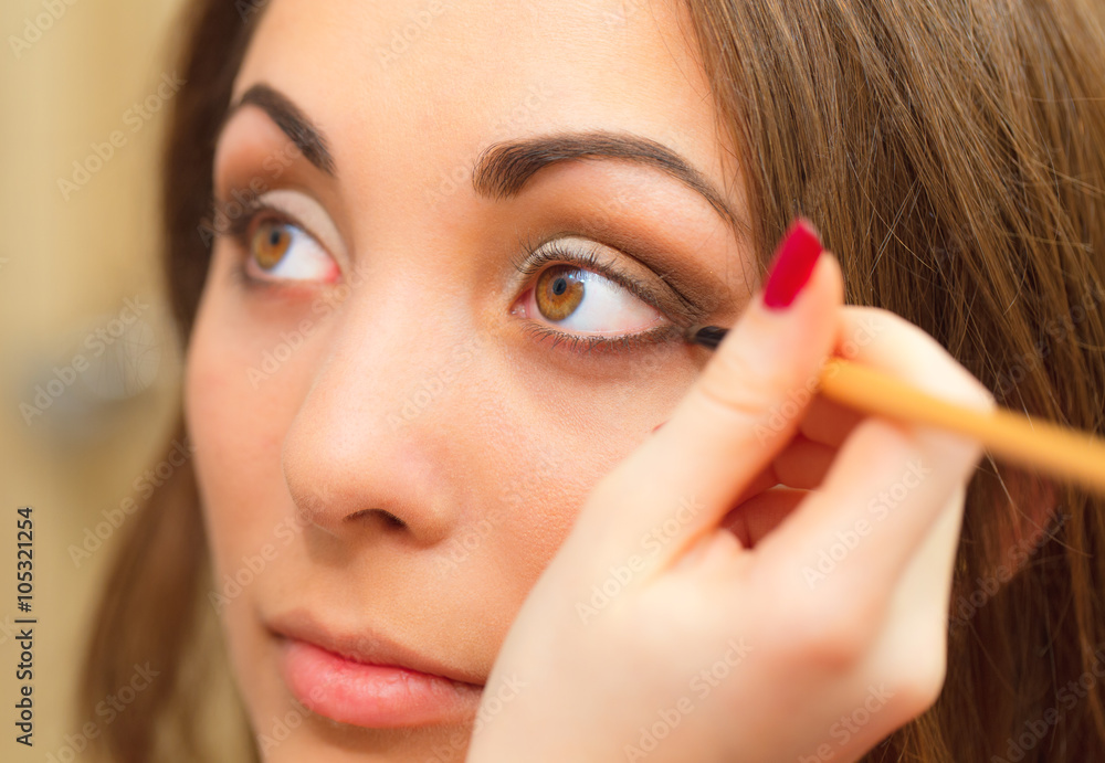 Applying makeup, eyeliner on a beautiful age-related woman face. Applying makeup, eyeliner on a beautiful age-related woman face.