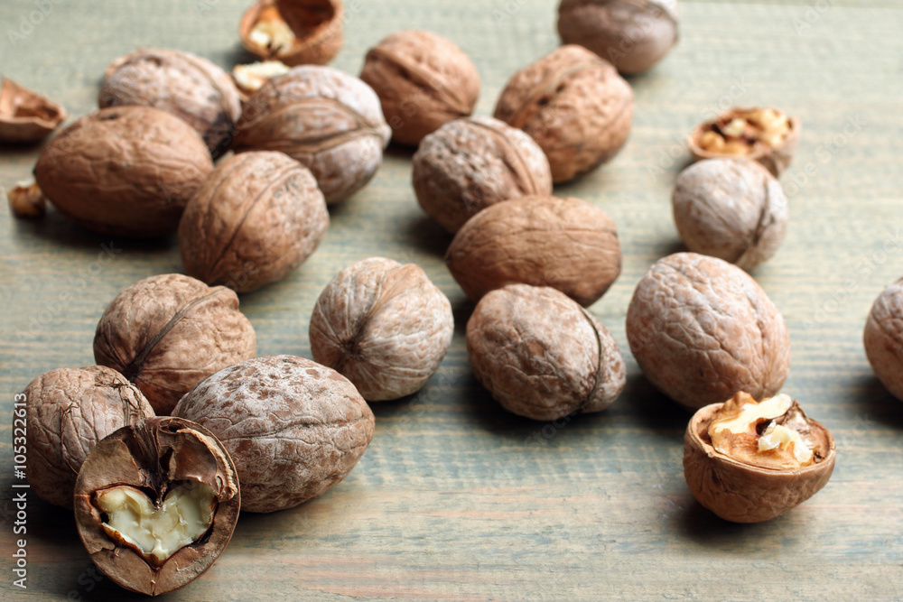 walnuts are broken on a brown wooden table walnuts are broken on a brown wooden table