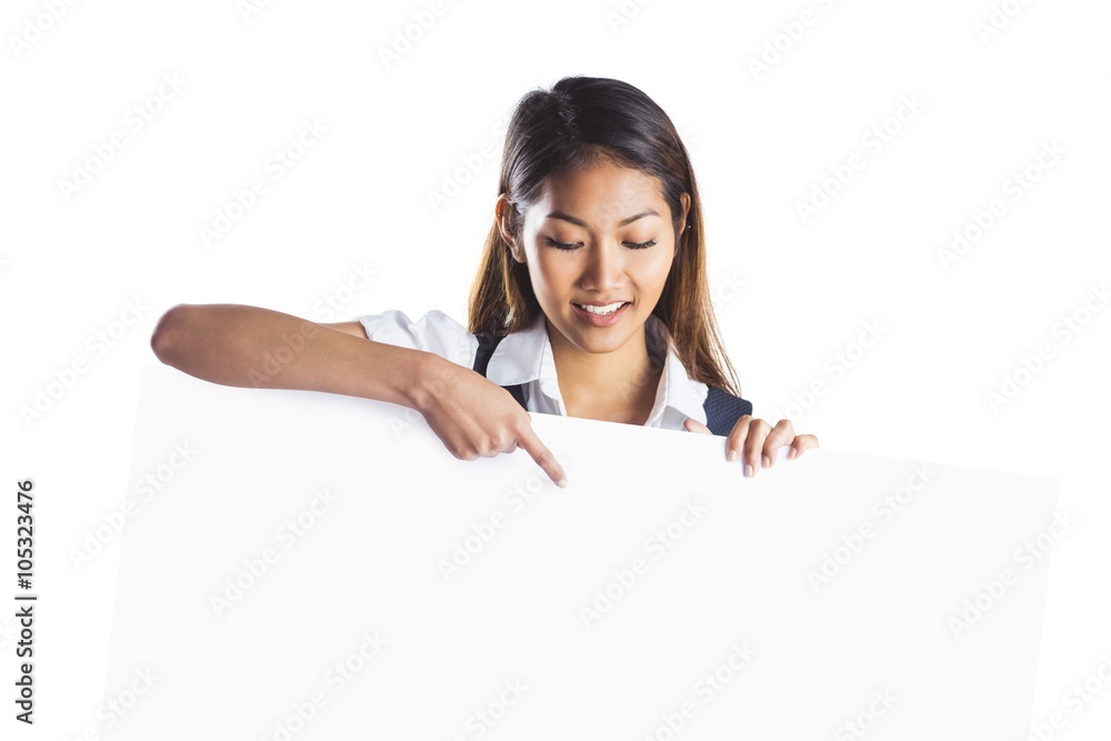 Smiling businesswoman pointing a white poster Smiling businesswoman pointing a white poster
