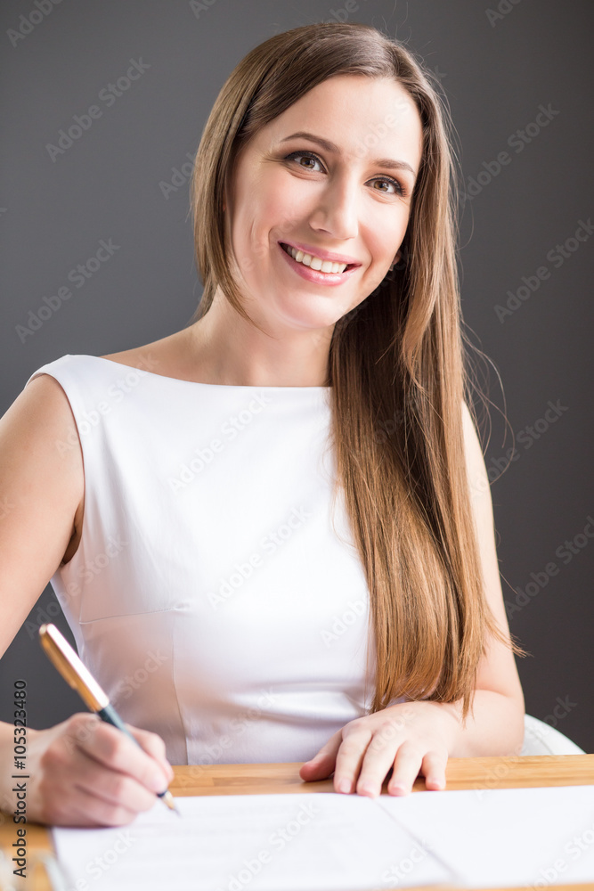 Young happy businesswoman signs contract in office Young happy businesswoman signs contract in office