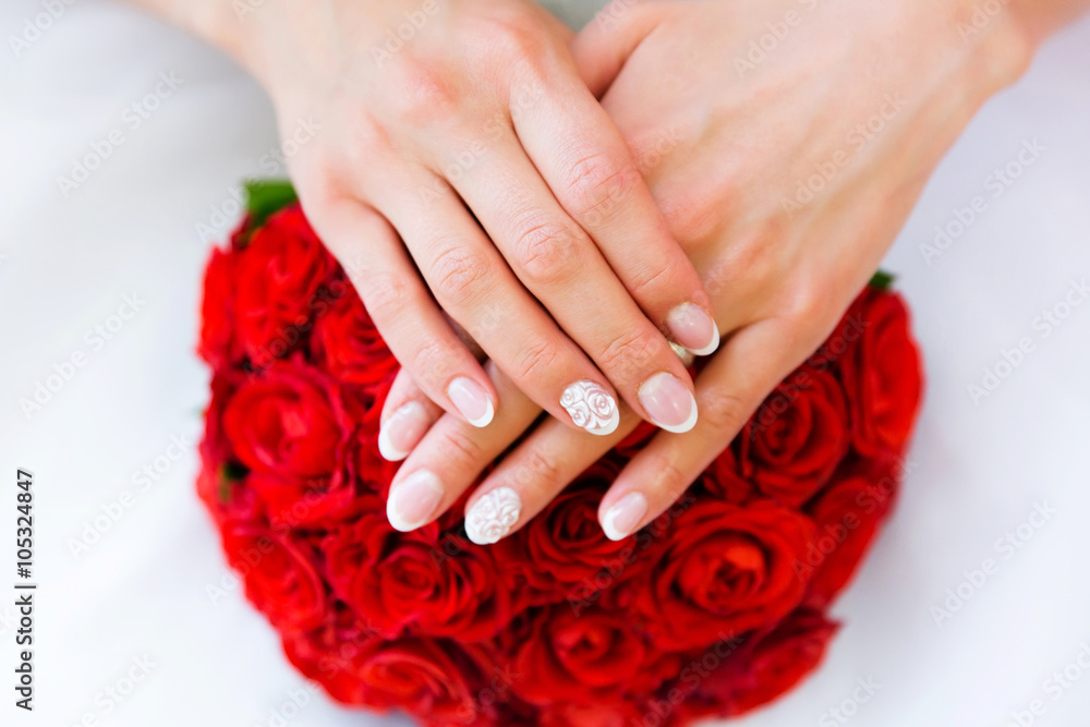 Fototapeta premium Red wedding bouquet of flowers and bride’s hands