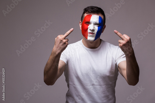 Brutal and angry huligan France football fan in game supporting of France national team on grey background. European football fans concept.