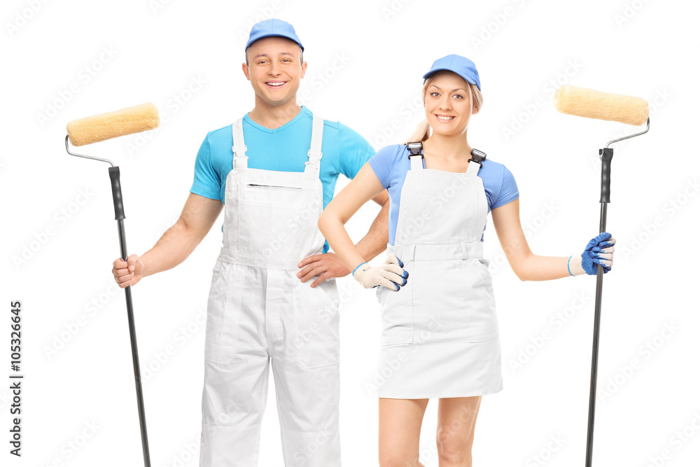 Male and female decorators holding paint rollers Male and female decorators holding paint rollers