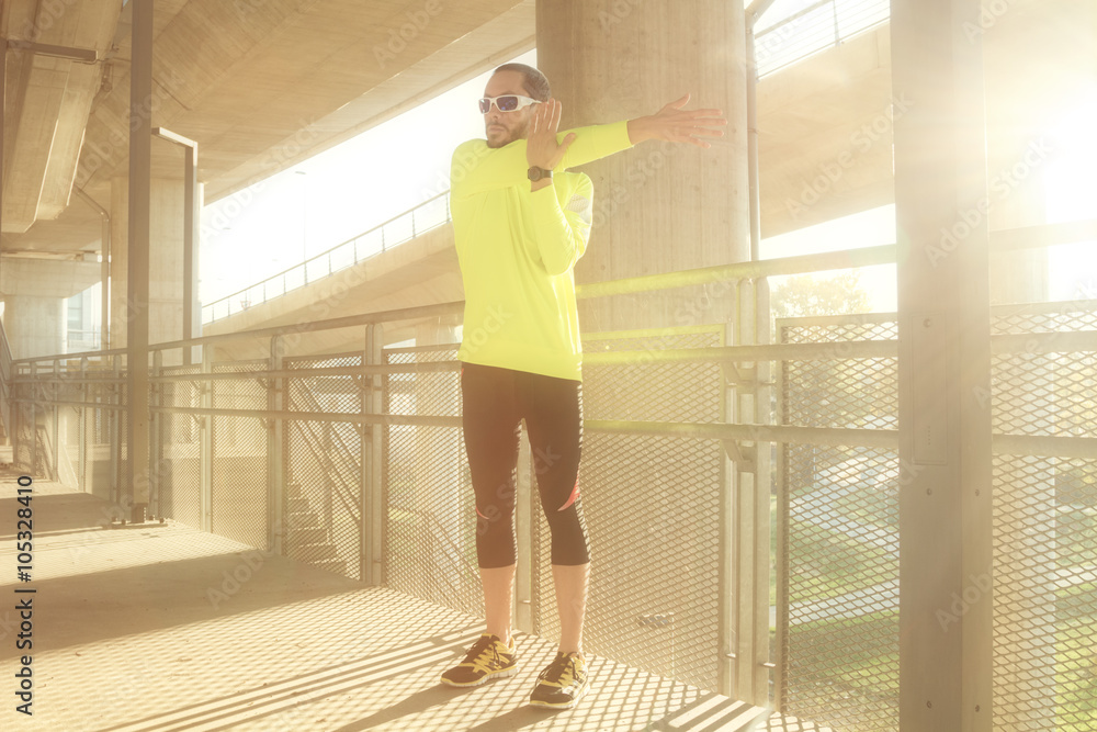 Obraz premium Stretching after jogging on a bridge.