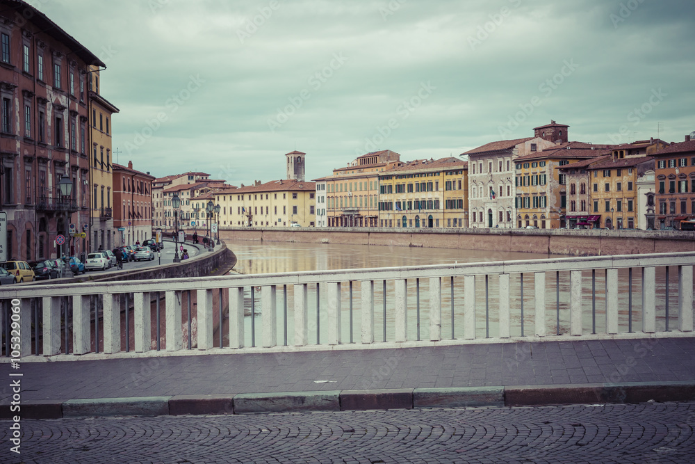 PISA, ITALY - MARCH 10, 2016: River Arno floating through the me