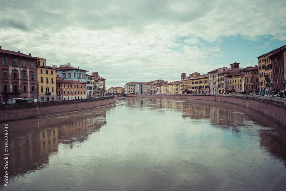 PISA, ITALY - MARCH 10, 2016: River Arno floating through the me