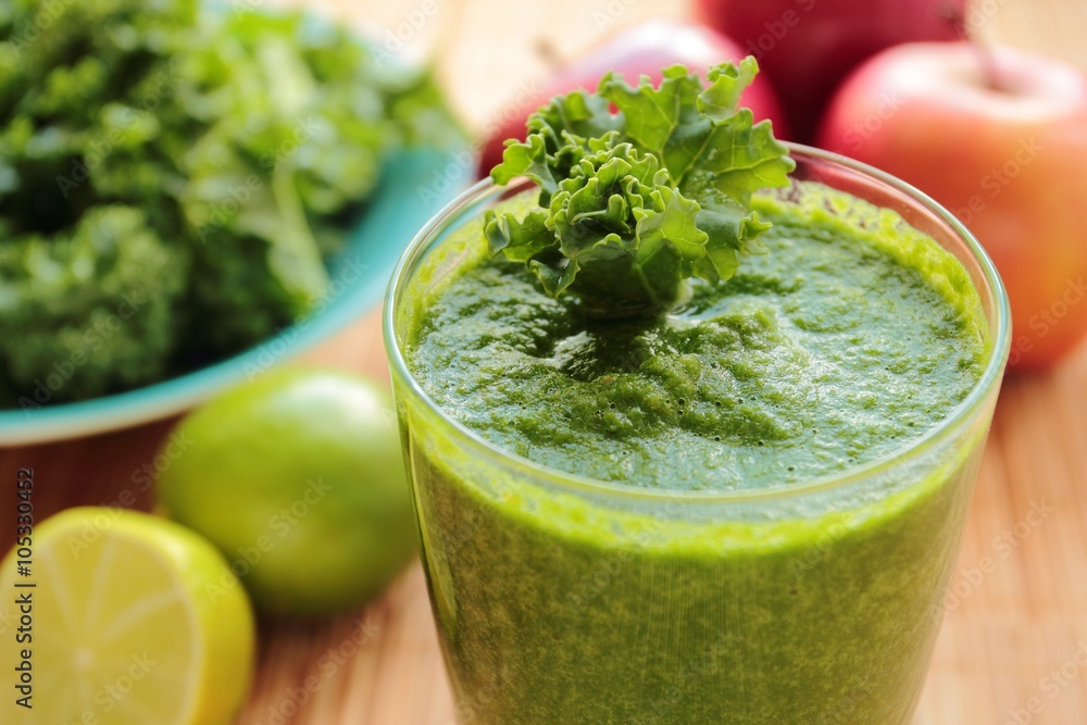 Glass with smoothie with green kale leafs, apple and lime Glass with smoothie with green kale leafs, apple and lime