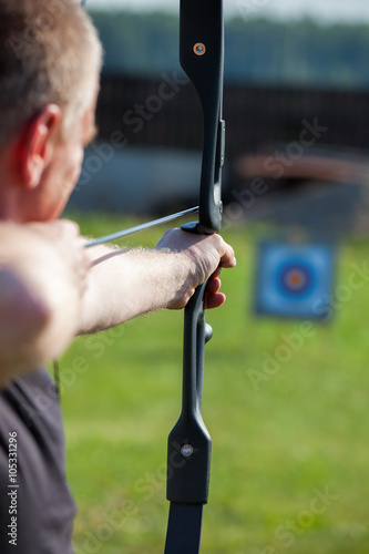 Man aiming bow at target