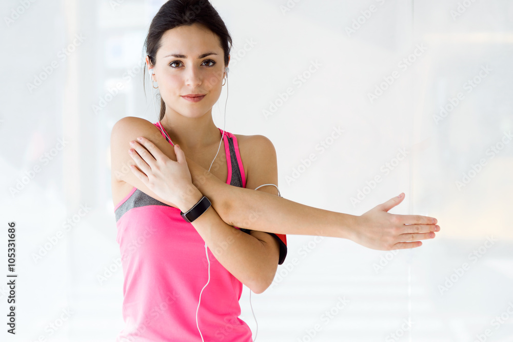Beautiful sporty young woman doing exercise in gym.