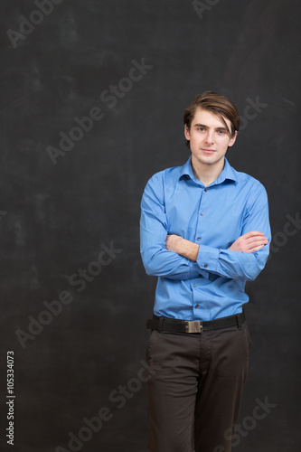 Portrait of a business man standing next to a blackboard.