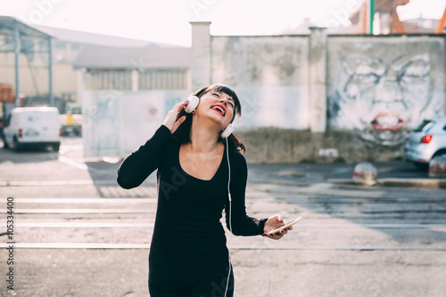 Knee figure of young beautiful eastern woman listening music wit © Eugenio Marongiu