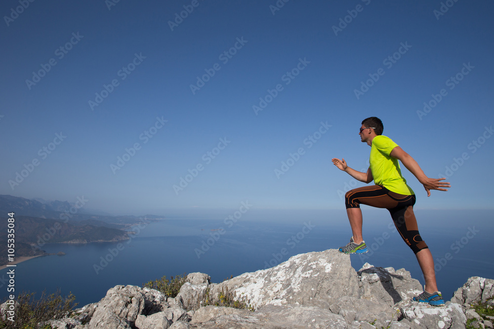 Trail runner training cardio running on rocky mountains yellow sand path in nature. 