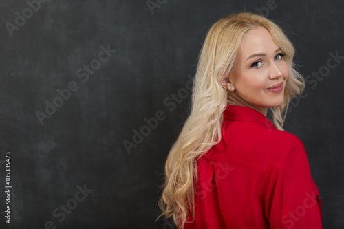 Blond woman in shirt against chalkboard, copyspace